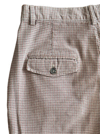 Houndstooth patterned pants with a pocket on a white background