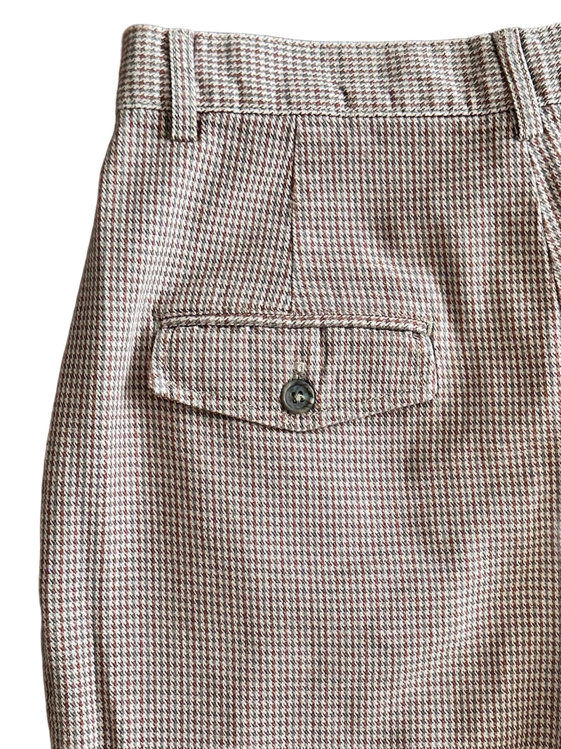 Houndstooth patterned pants with a pocket on a white background