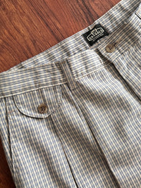 Blue plaid pants with a brand label on a wooden surface