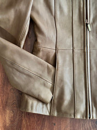 Close-up of a tan leather jacket on a wooden surface