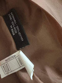 Close-up of a leather jacket label with text on a brown background