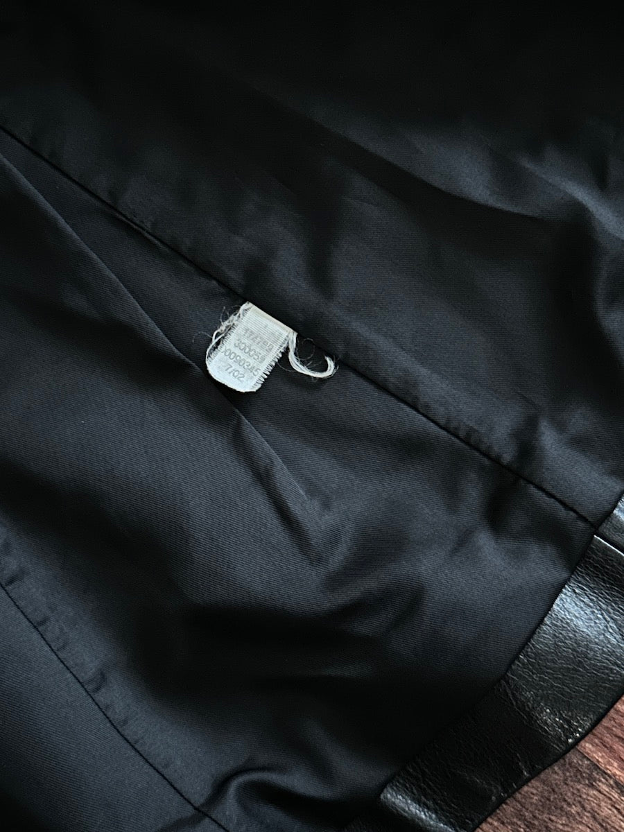 Close-up of a black jacket lining with a tag on a dark background