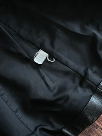 Close-up of a black jacket lining with a tag on a dark background