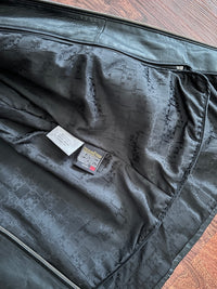 Lining of a black leather jacket with a label on a wooden surface