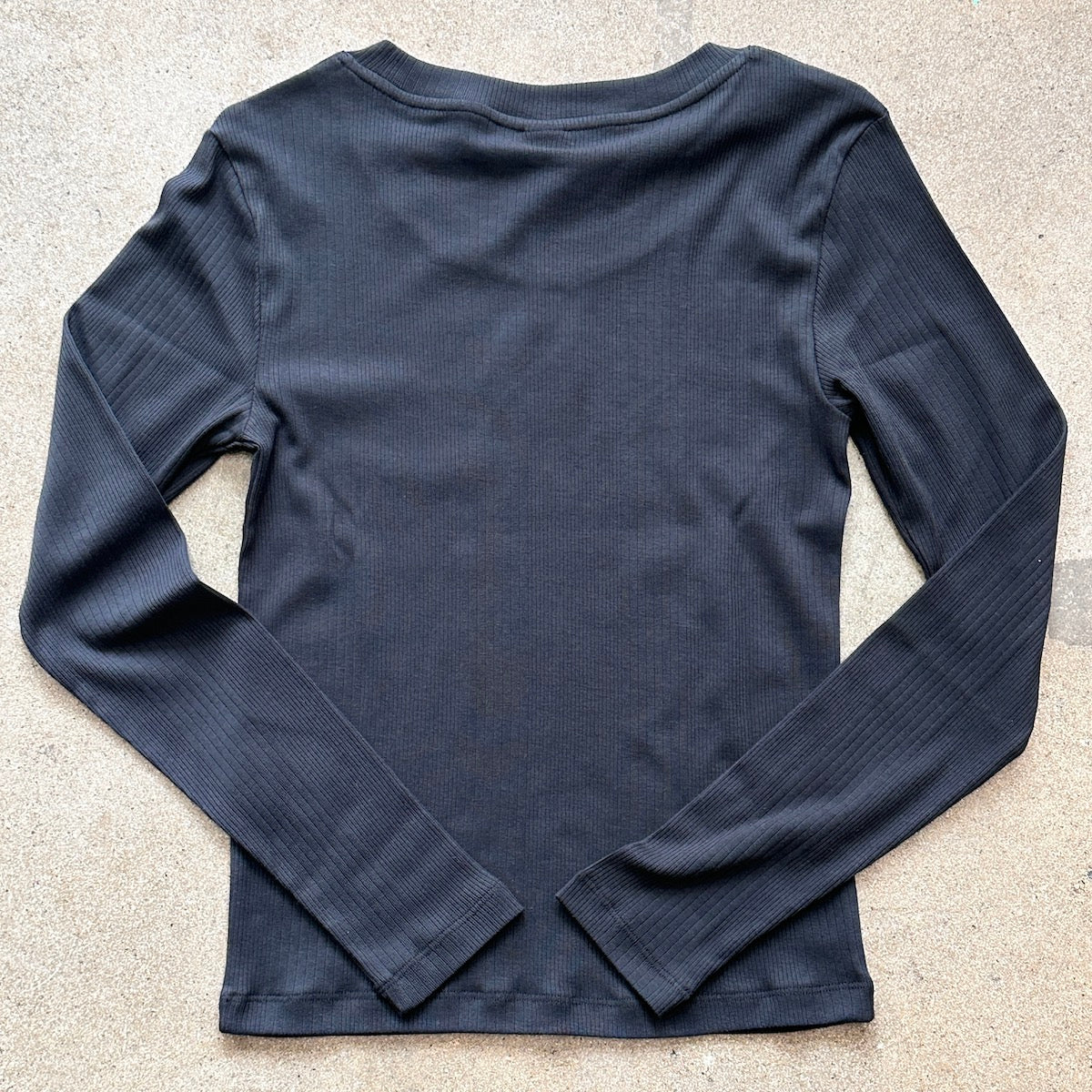 Black long-sleeve shirt on a light gray background