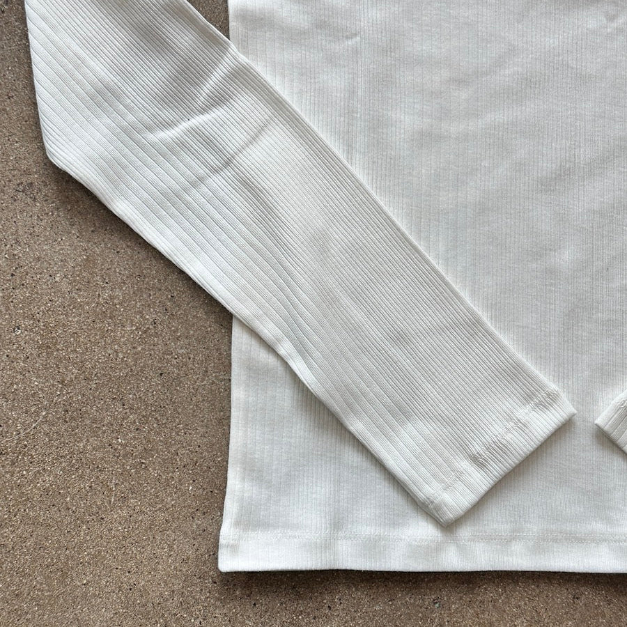 White shirt with long sleeves on a brown surface