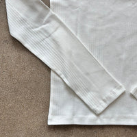 White shirt with long sleeves on a brown surface