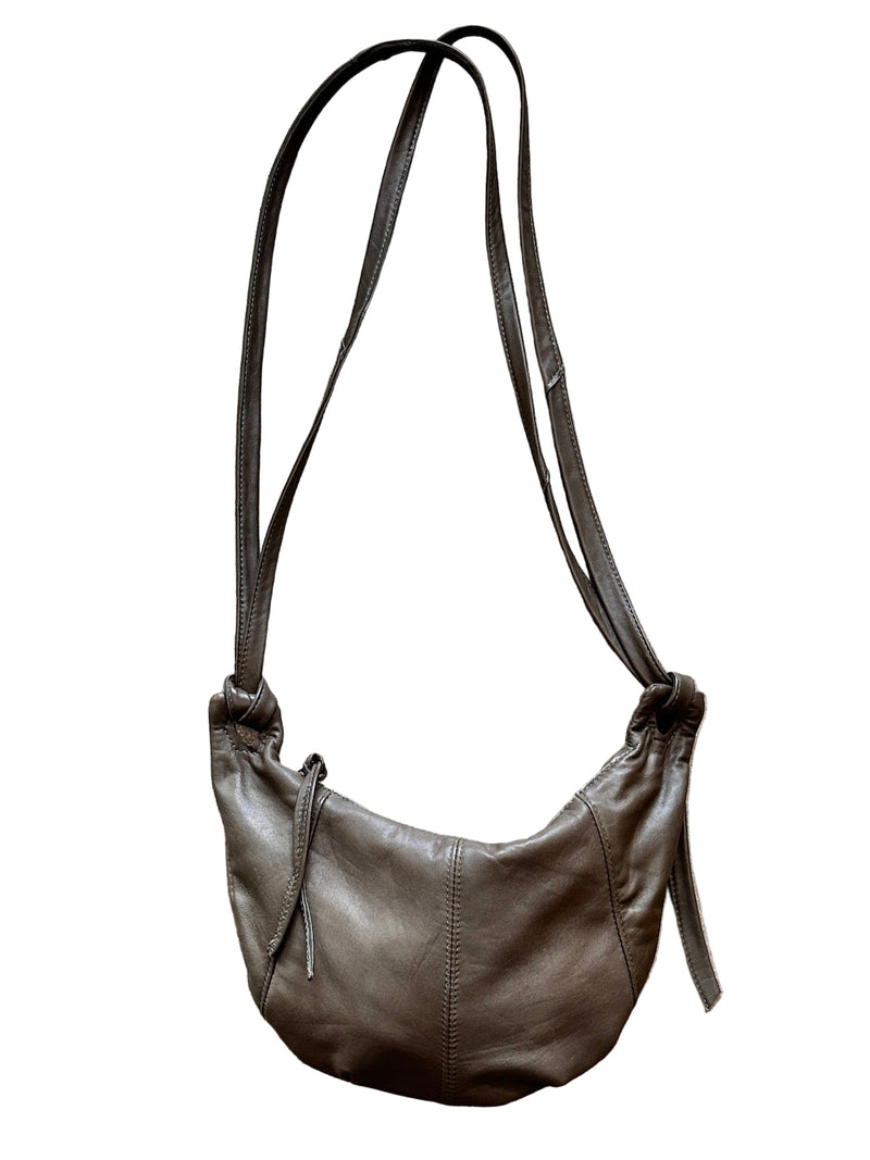 Taupe leather shoulder bag on a textured stone surface