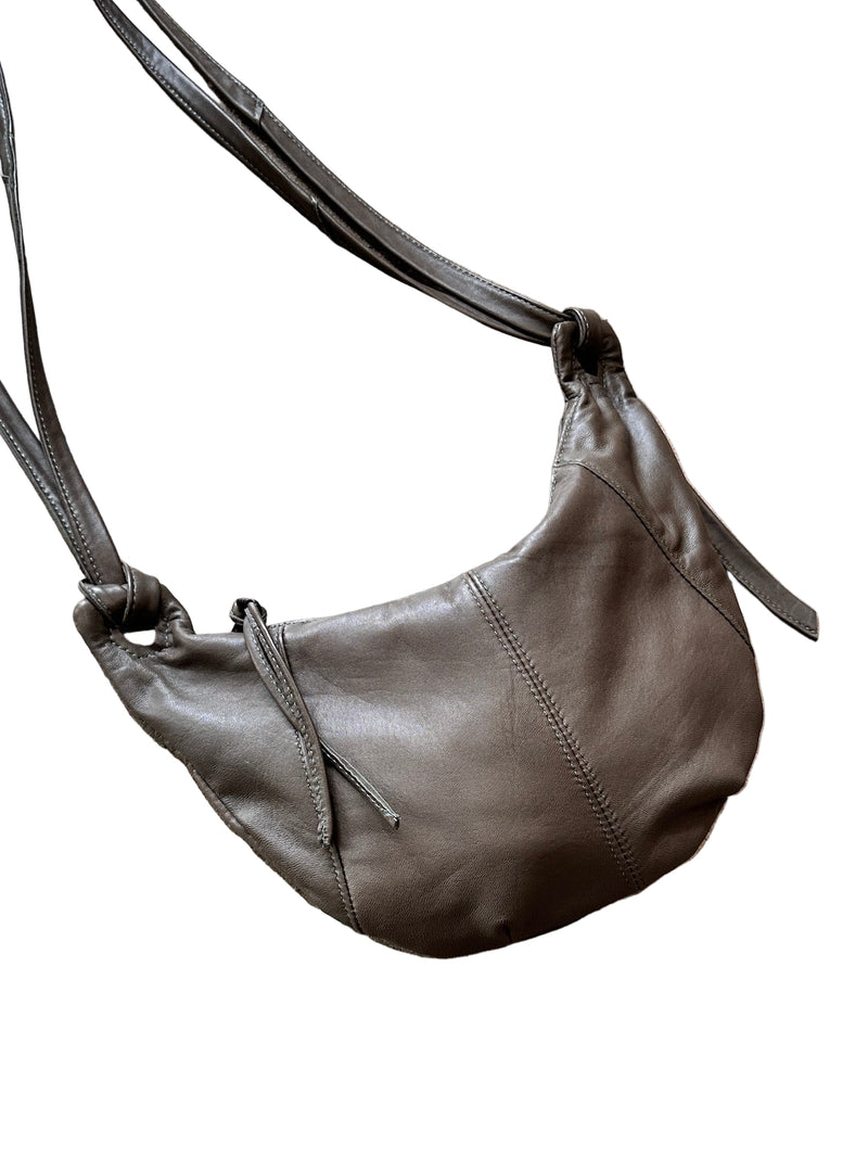 Taupe leather shoulder bag on a concrete floor