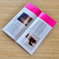 Open magazine with images and text on a wooden surface