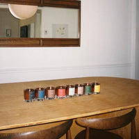 Row of candles on a wooden table with a mirror above
