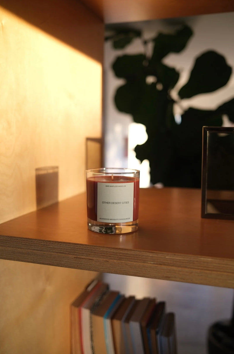 Candle in a glass vessel on a wooden surface with a blurred background