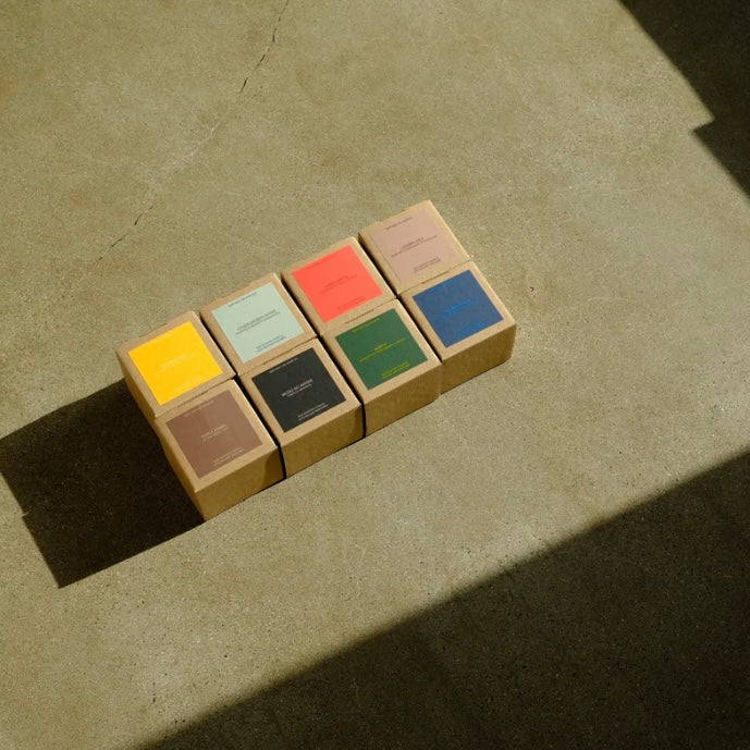 Set of small cardboard boxes with colored labels on a textured surface