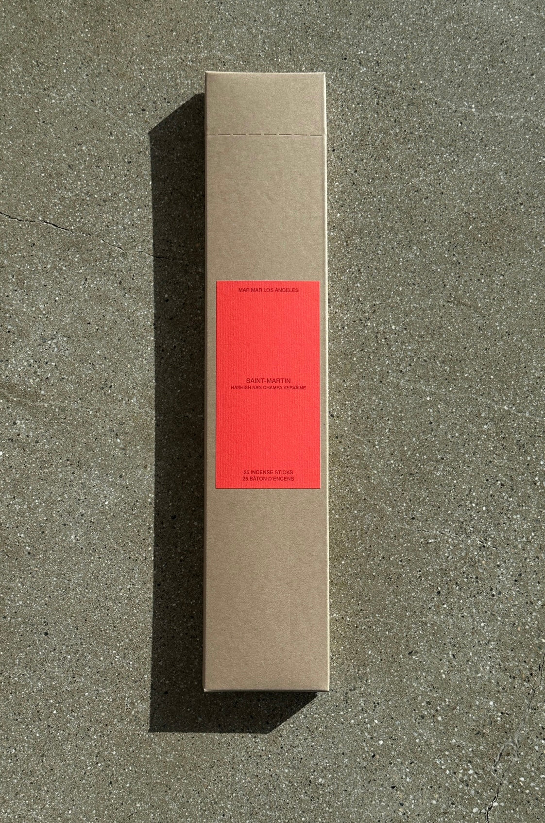 Cardboard box of incense with red label on a concrete surface