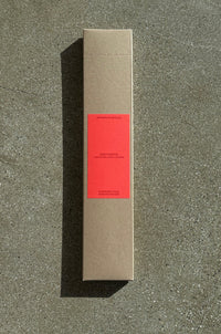 Cardboard box of incense with red label on a concrete surface