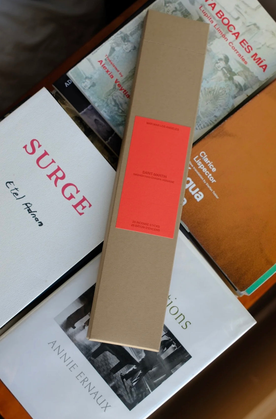 Cardboard incense box with a red label on top of books