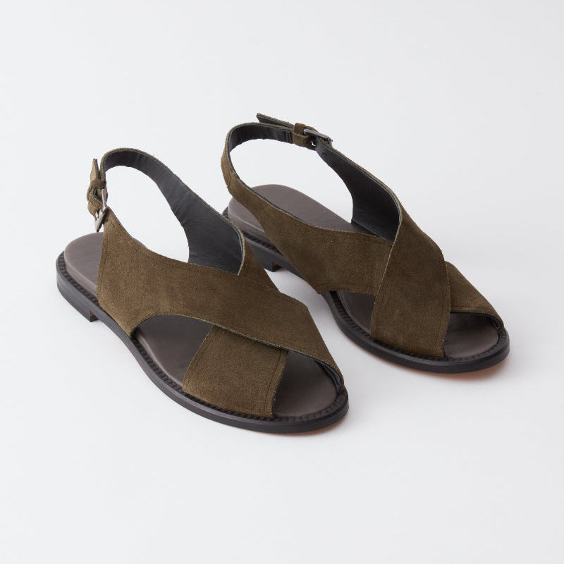 Pair of green suede sandals on a white background