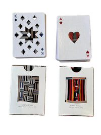 Four playing cards stacks with geometric designs on a wooden surface