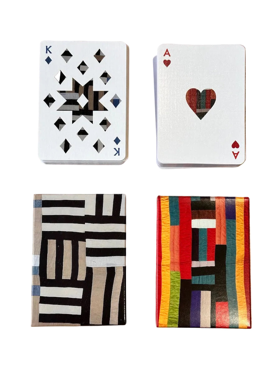 Four playing cards stacks with geometric designs on a wooden surface