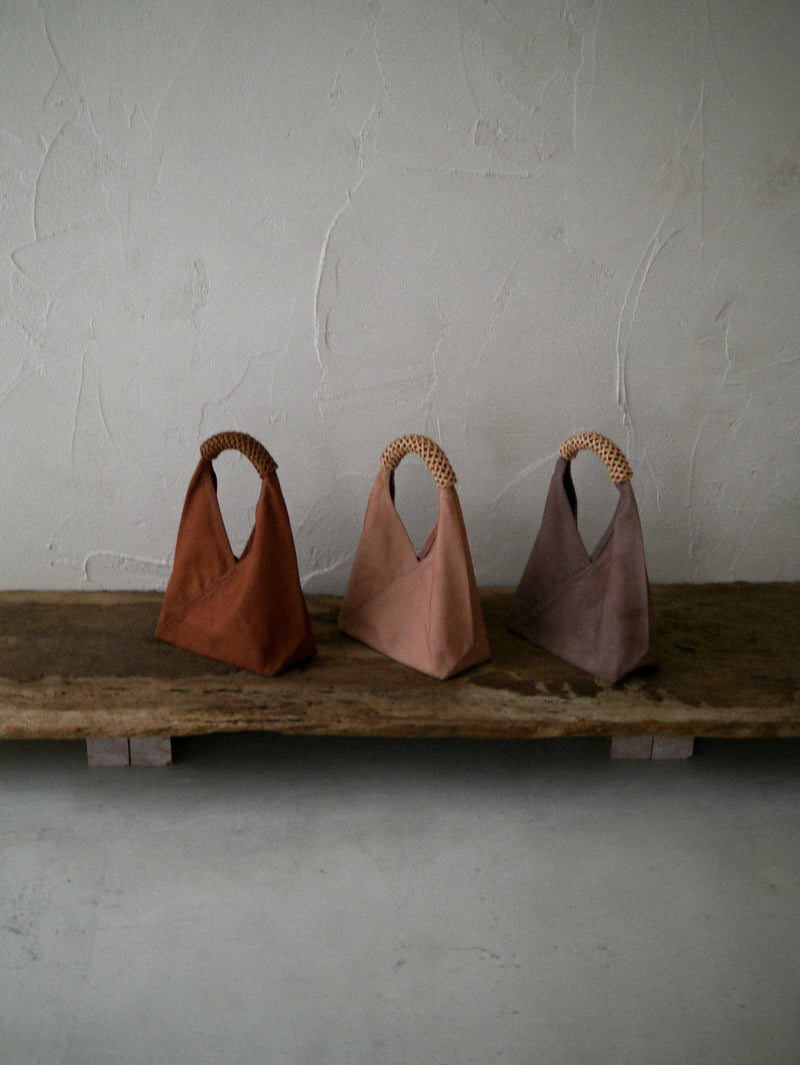 Three colored bags on a wooden ledge
