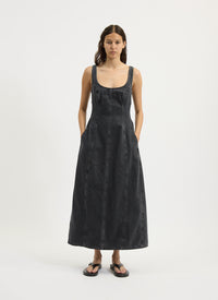 Woman wearing a black sleeveless denim dress on a white background