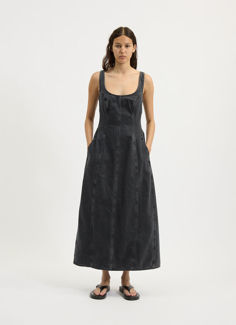 Woman wearing a black sleeveless denim dress on a white background