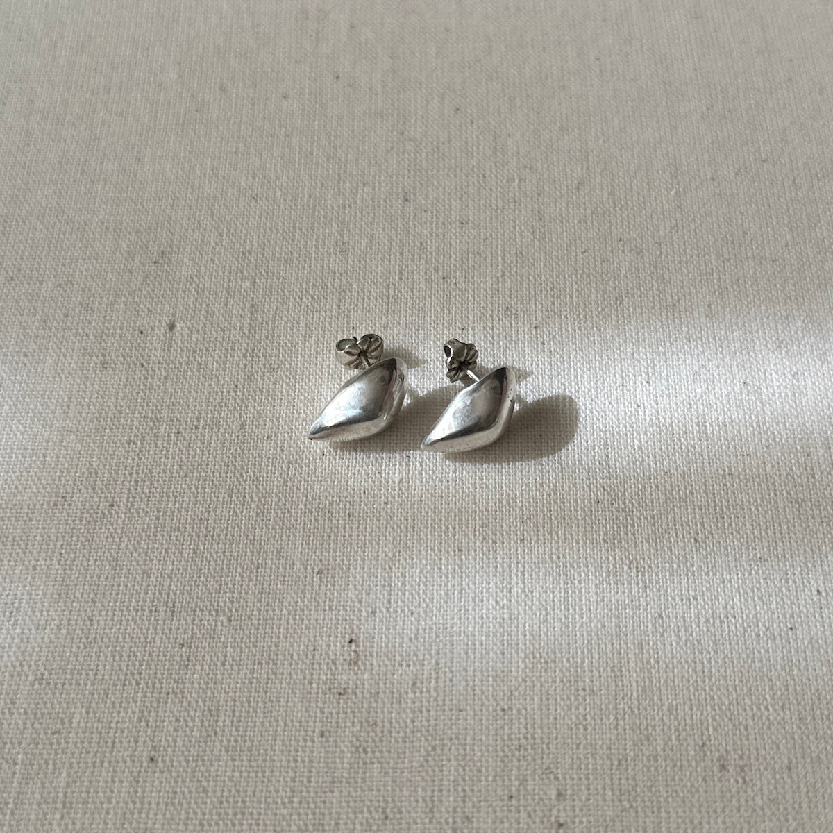 Pair of silver earrings on a light fabric background