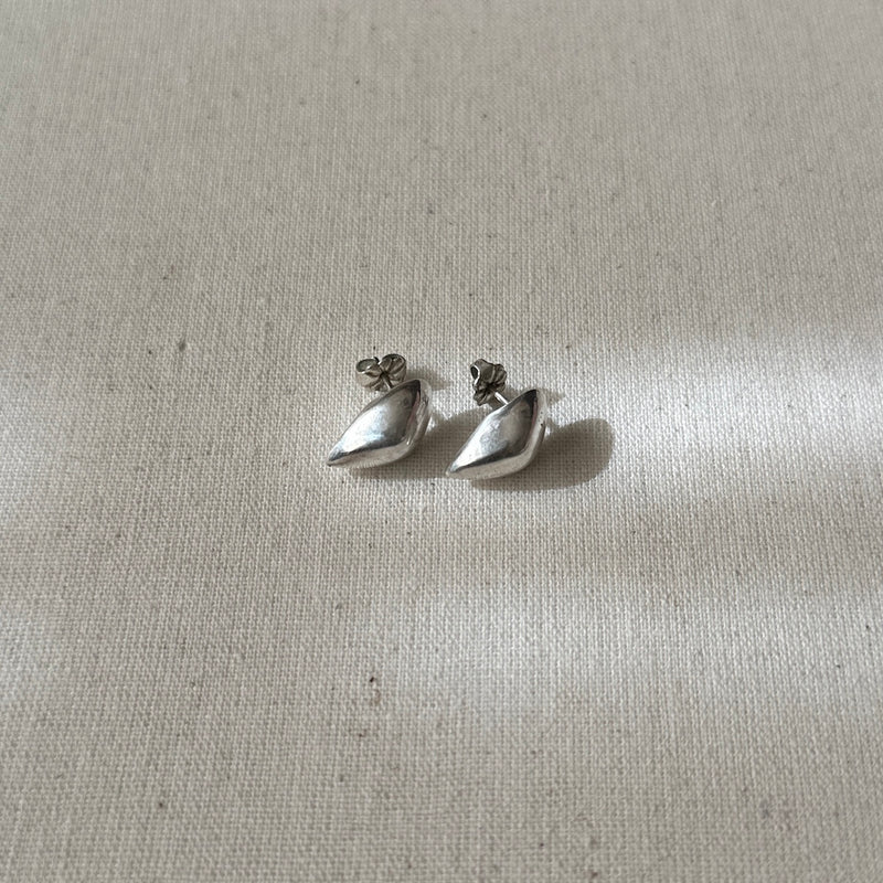 Pair of silver earrings on a light fabric background