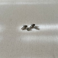 Pair of silver earrings on a light gray fabric background