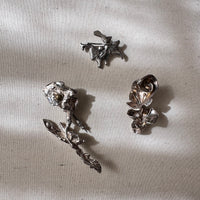 Set of silver pendants and brooches on a textured beige surface