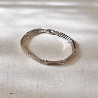Silver bracelet on a textured beige surface