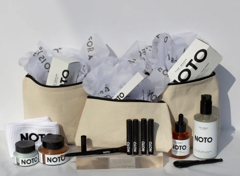 Grooming kit with various products and a beige pouch on a white background