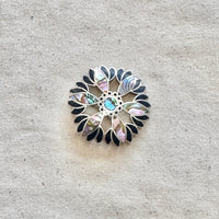 Decorative brooch with floral pattern on a textured beige background