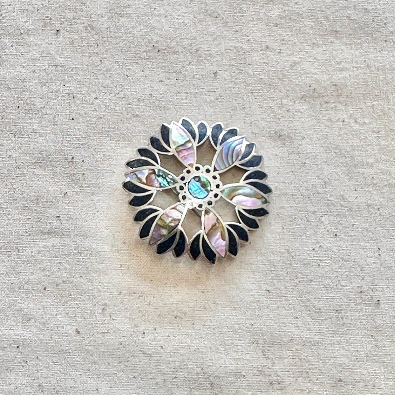 Decorative brooch with floral pattern on a textured beige background