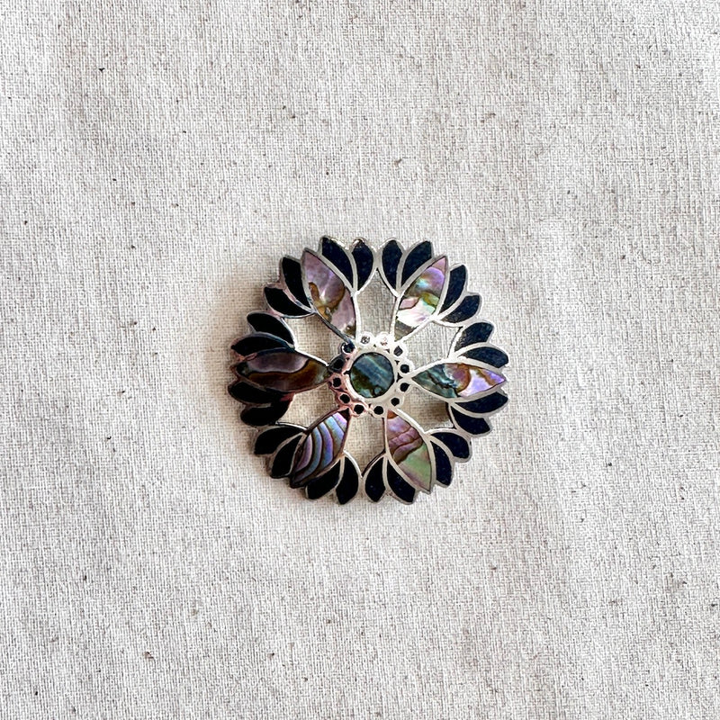 Decorative brooch with a floral pattern on a textured beige background