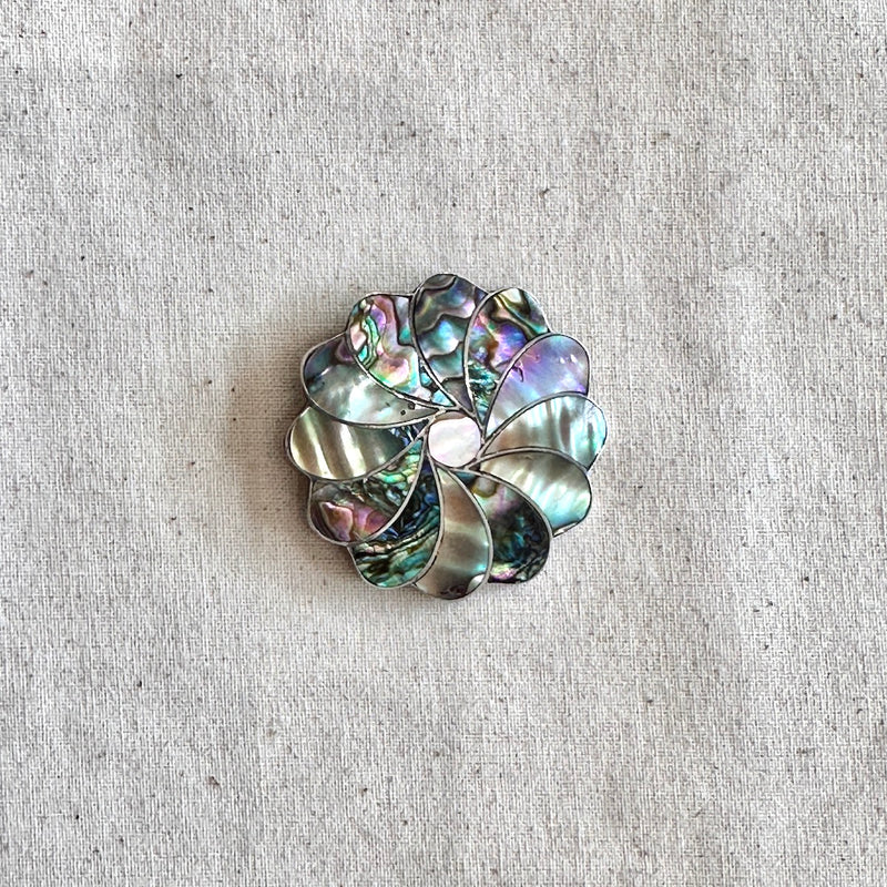 Decorative brooch with floral design on a textured beige background