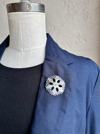 Floral brooch on a blue jacket lapel with a mannequin background