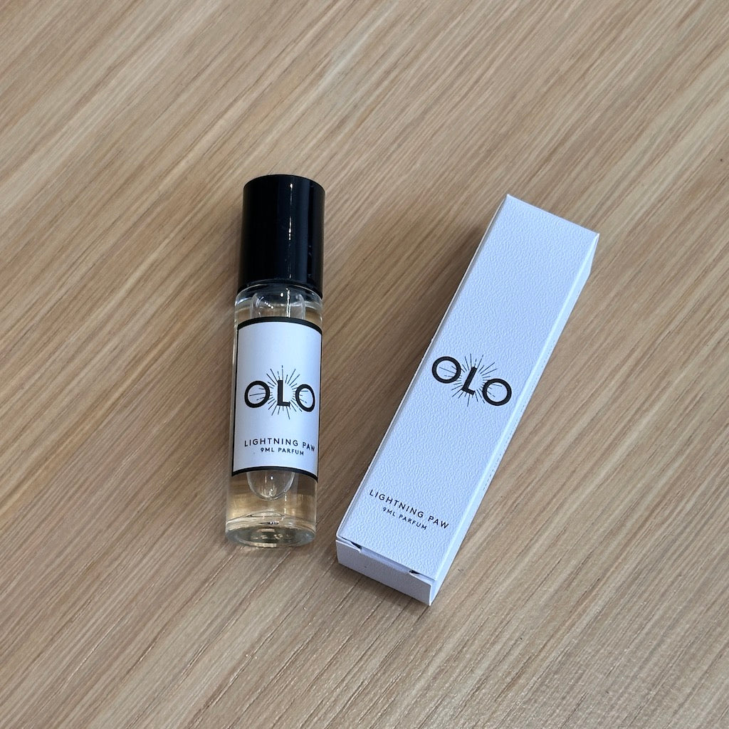 OLO perfume bottle and packaging on a wooden surface