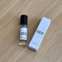 OLO perfume bottle and packaging on a wooden surface