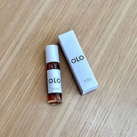 OLO perfume bottle and packaging on a wooden surface
