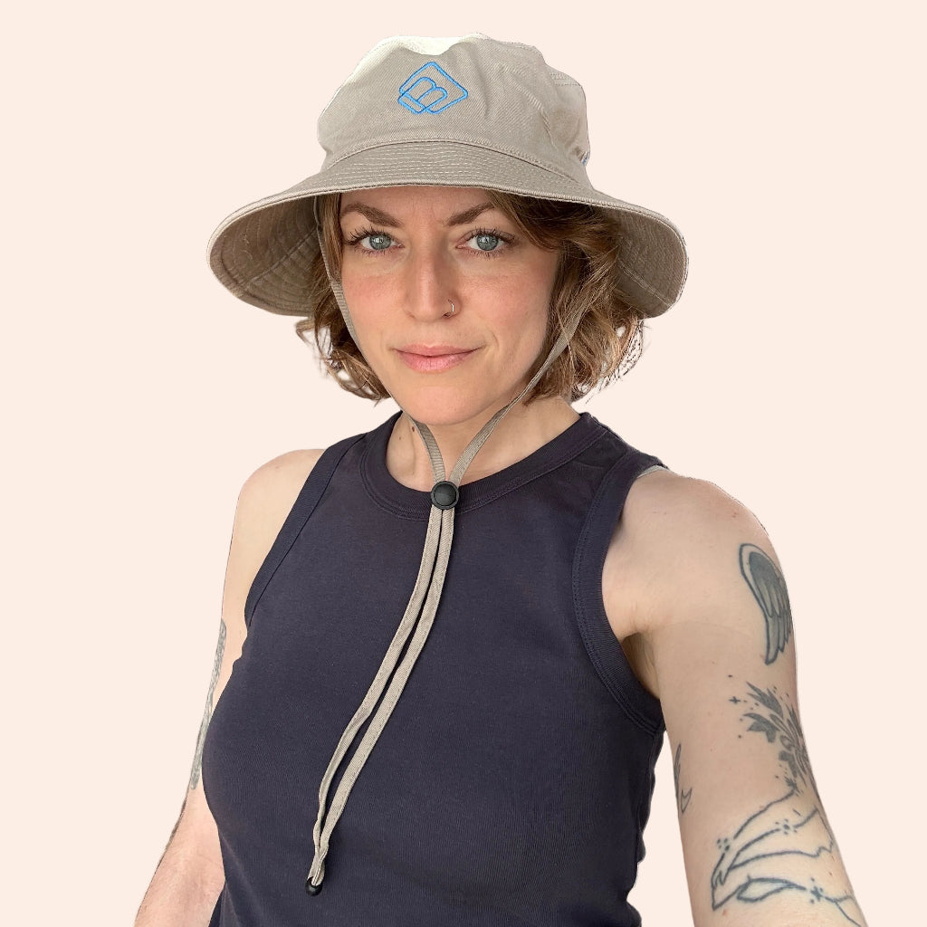 person wearing a wide brim hat with adjustable chin strap and embroidered logo