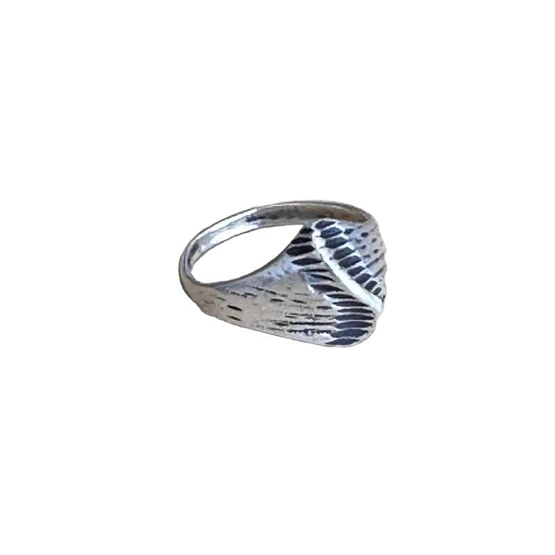 Silver ring with a textured design on a white background