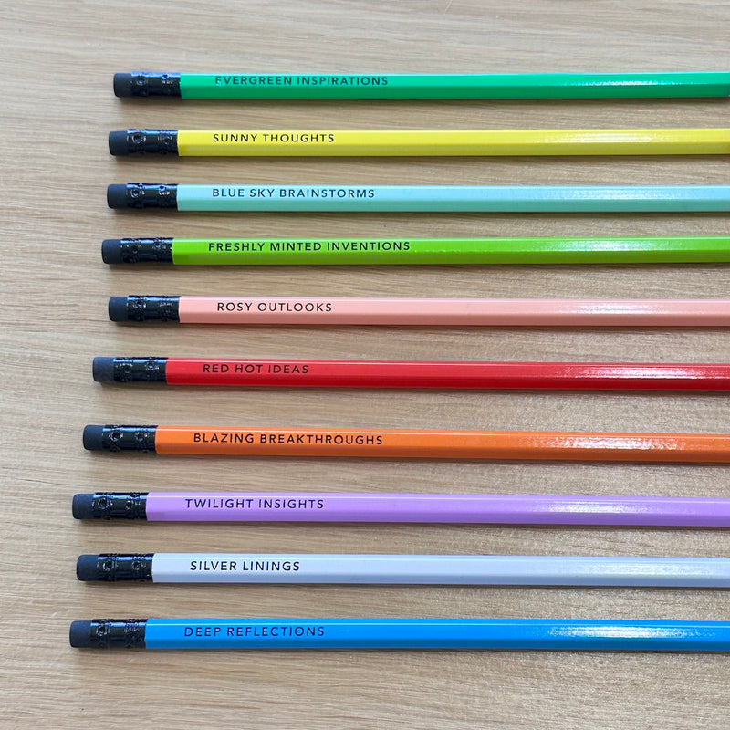 Row of colorful pencils with motivational phrases on a wooden surface