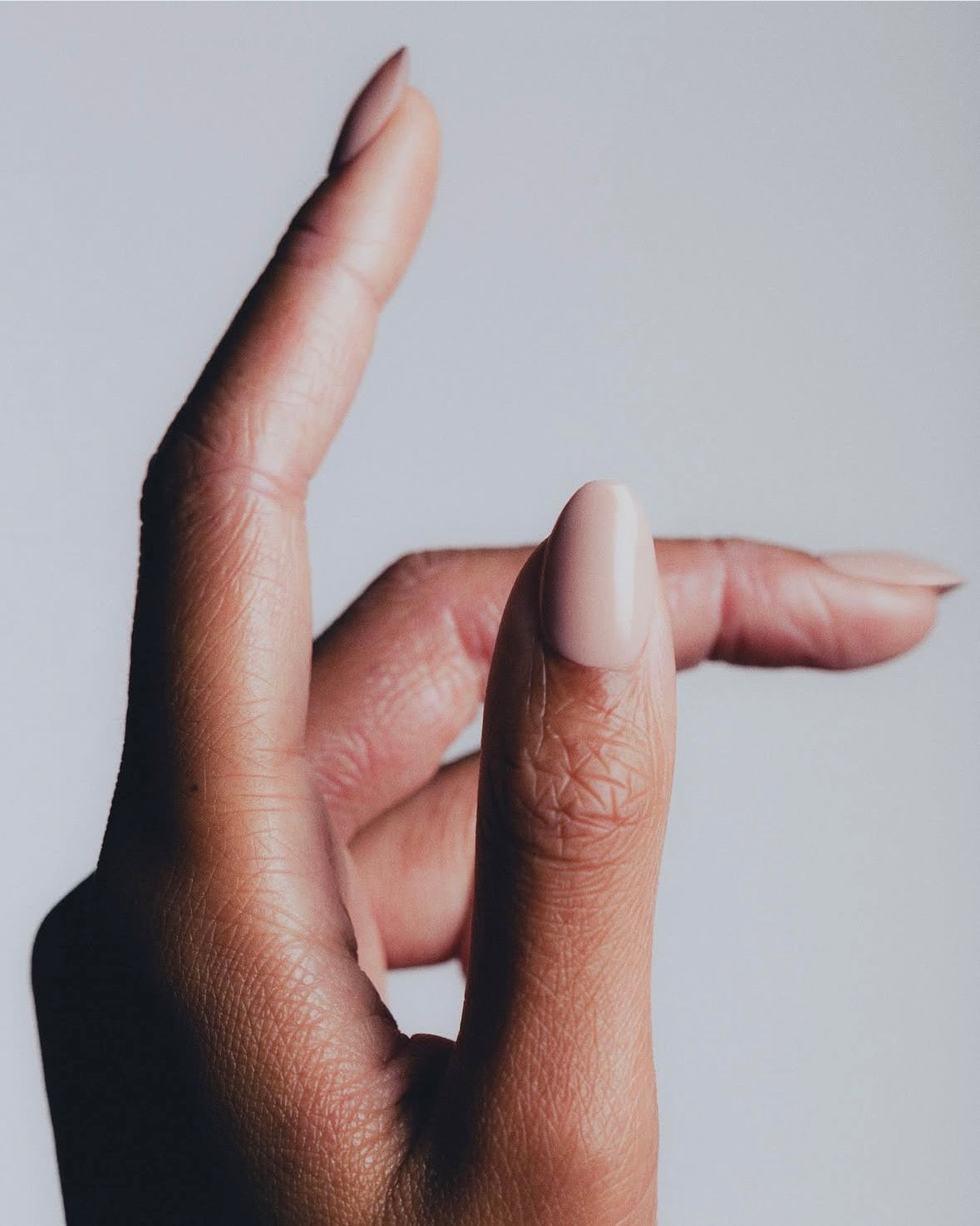 Hand with light pink nail polish