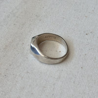 Silver ring with 'Mexico' engraving on a light fabric background