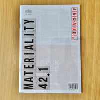 A magazine or book cover titled 'MATERIALITY 42.1' with 'ARCADE' in red block letters, photographed flat on a light wood surface.