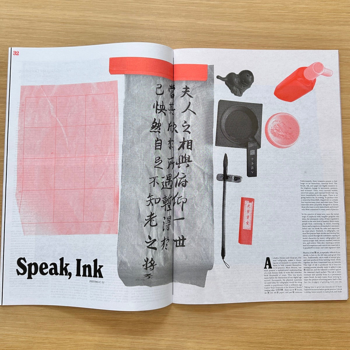 An open magazine or book spread laid flat on a light wood surface, featuring a page with the headline 'Speak, Ink,' a large pink calligraphy practice sheet, a gray vertical brush-stroke panel with Chinese characters, and several ink-related objects including a black ink bottle, a red ink pot, a round pink ink well, and a black ink stick.