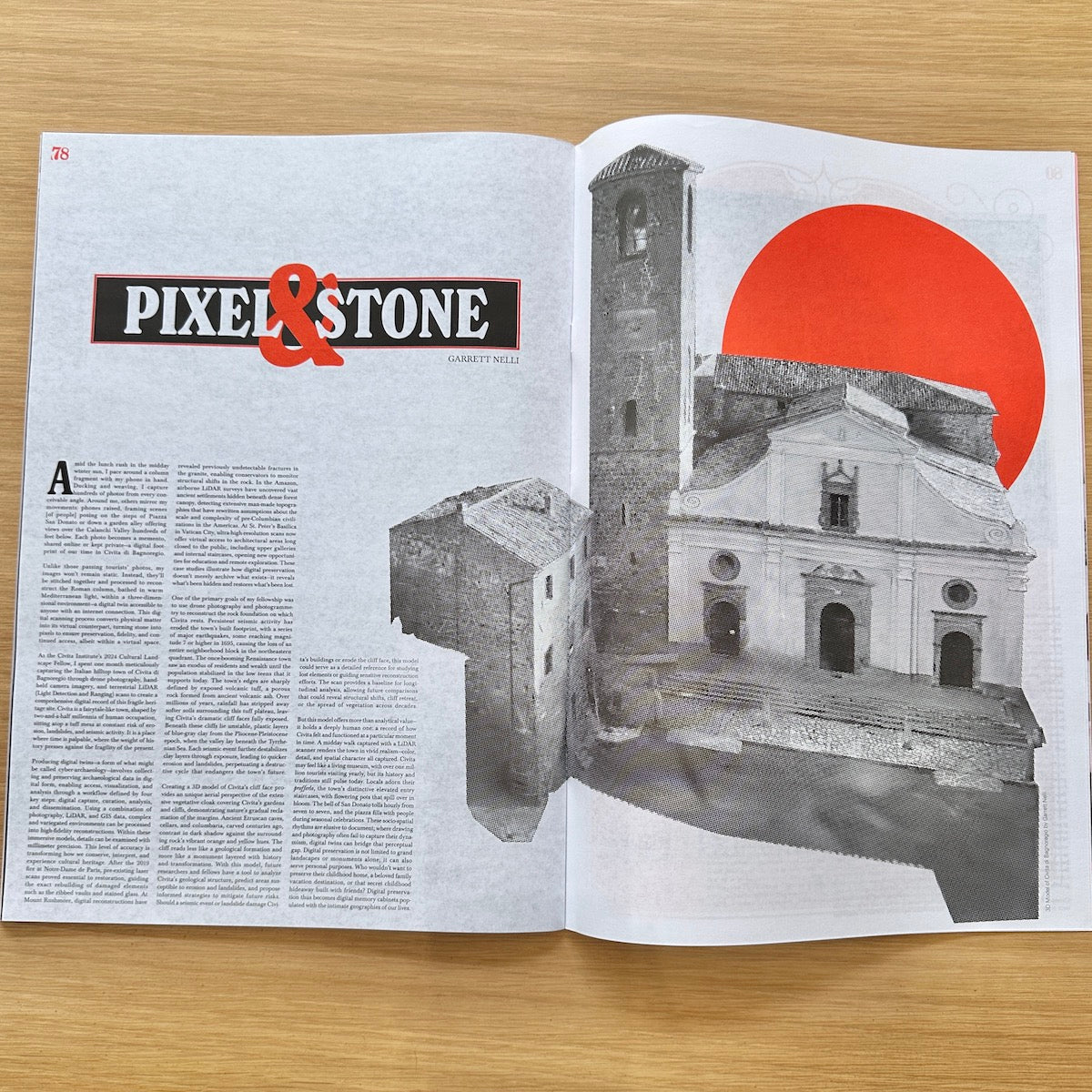 An open magazine or book spread on a light wood surface, featuring the title 'PIXEL & STONE' in black and red text on the left page and a grayscale architectural photograph with a large red sun graphic on the right page.