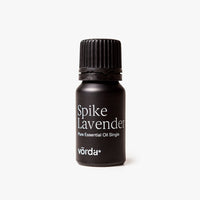 A small black bottle of Vörda Spike Lavender pure essential oil single, featuring a black ribbed cap and white text, set against a clean off-white background.