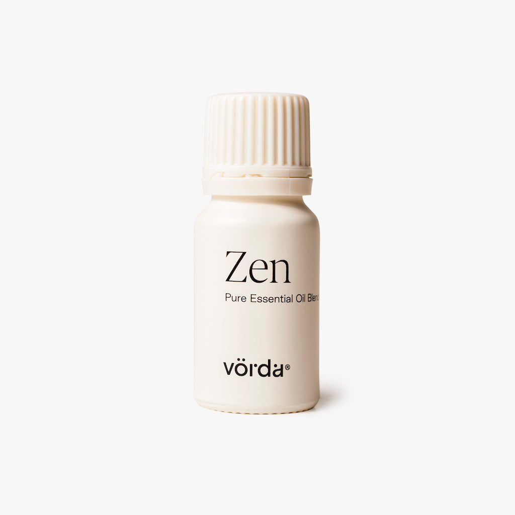 Off-white bottle with ribbed cap labeled 'Zen Pure Essential Oil Blend' and 'vörda' on a light grey background